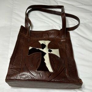 Ladies real leather bag with a cross on it snap closure in the middle!
